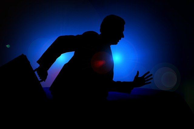 běžící kancelářský muž na modrém pozadí ve tmě