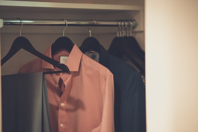 Oblečení na ramínkách ve skříni